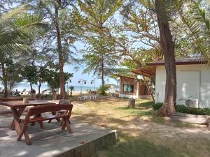 a picnic table next to a house with a view of the beach at Lanta Island Resort in Ko Lanta