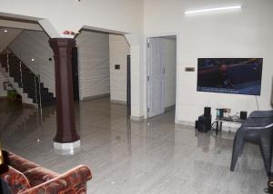 salon z kanapą i telewizorem na ścianie w obiekcie Thotadagadde Home stay w mieście Mudigere