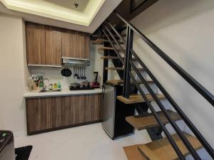una cocina con una escalera junto a una cocina con nevera en A2J Luxury 2BR Suite Near High Street BGC Taguig, en Manila