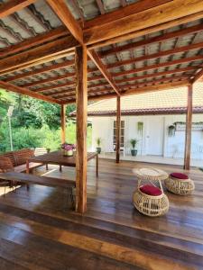 un pabellón con mesa y sillas en un suelo de madera en Private Homestay with 2 bedroom and comfort tent en Bentong