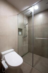 La salle de bains est pourvue de toilettes et d'une douche en verre. dans l'établissement Hanwha Resort Gyeongju, à Gyeongju