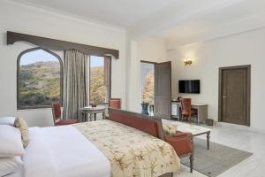 a hotel room with a bed and a large window at Fateh Vilas by Fateh Collection in Udaipur