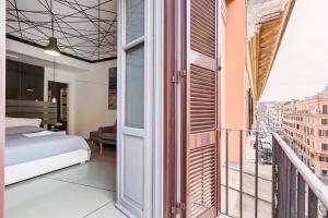 ein Schlafzimmer mit einem Bett und einem Balkon in der Unterkunft The Upper Suites in Rom