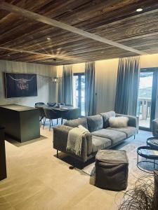 a living room with a couch and a dining room at Hameau des Prodains - Résidence in Morzine