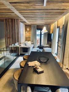 sala de estar con mesa y algunas sillas en Hameau des Prodains - Résidence en Morzine