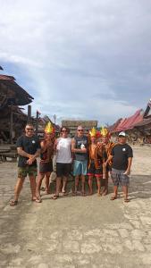 a group of people posing for a picture on the beach at Aloha Guest House Nias in Hilibotodane