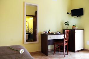 a bedroom with a desk and a chair in a room at Agriturismo Montalbano in Cartabubbo