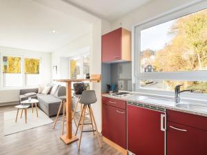 a kitchen with red cabinets and a large window at Zur Altstadt in Monschau