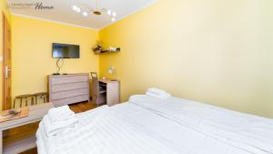 Duas camas brancas num quarto com televisão em Wonder Home - Apartament Grey w spokojnej okolicy - blisko terenów zielonych em Karpacz
