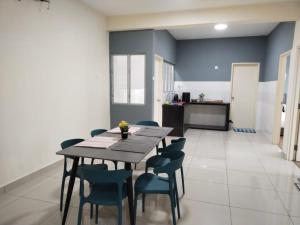 ein Esszimmer mit einem Holztisch und Stühlen in der Unterkunft 3 bedrooms big house saville cheras MRT with balcony in Cheras