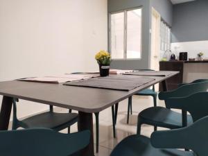 einen Esstisch mit Stühlen und eine Vase mit Blumen darauf in der Unterkunft 3 bedrooms big house saville cheras MRT with balcony in Cheras