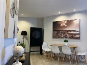 a dining room with a table and white chairs at La Laguna Luxe Apartment in La Laguna