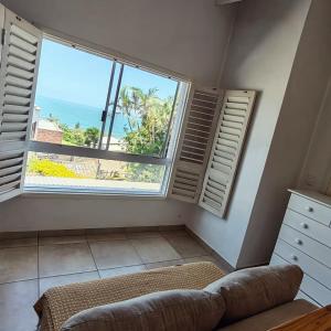 a living room with a large window and a couch at Villa Saira-Holiday villa across the beach! in KwaDukuza