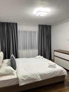 a bedroom with a large white bed with curtains at Vila AliBi Valiug - 200m from Ponton Casa Baraj in Văliug