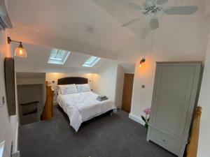 Schlafzimmer mit einem Bett und einem Deckenventilator in der Unterkunft Brigstone Stable - charming peaceful cottage in Lothersdale