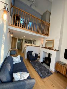 a living room with a blue couch and a fireplace at Brigstone Stable - charming peaceful cottage in Lothersdale