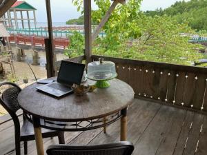 a table with a laptop on top of a deck at Areef Homestay Kaledupa in Kaledupa