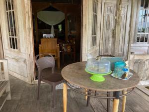 una mesa con un tazón en el porche en Areef Homestay Kaledupa, en Kaledupa