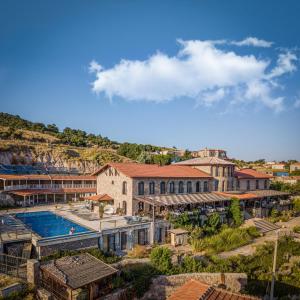 un grand bâtiment avec une piscine dans une ville dans l'établissement Assos Sunaba Kasri Hotel, à Assos