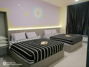 two beds sitting next to each other in a bedroom at StoberiCekelatHomestaymuslim's in Brinchang