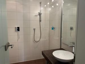 ein Badezimmer mit Dusche, Waschbecken und Toilette in der Unterkunft Boardinghouse am Wall in Salzgitter-Bad + 17 Fotos