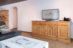 شقة جونغفراو لودج في جريندلفالد: غرفة معيشة مع تلفزيون فوق خزانة خشبية