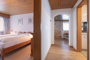 a bedroom with a bed and a dining room at Apartment Jungfrau Lodge in Grindelwald