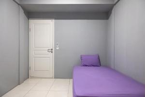 a purple bed in a room with a door at Graha Asri Syariah in Waru