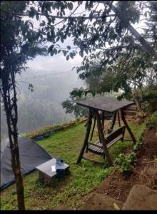 uma mesa de piquenique e uma tenda no topo de uma colina em 4REST INN PRIVATE LIMITED em Kodaikanal