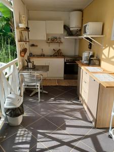 a kitchen with white cabinets and a tiled floor at Le nid douillet du p'tit caillou in Bernica-les Bas