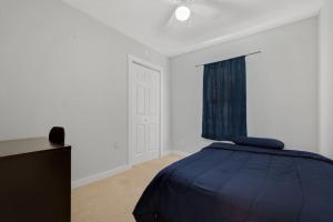 a bedroom with a blue bed and a window at Near Bishop Arts District Spacious 3 Bedroom Home! in Dallas