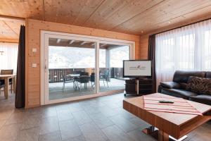 een woonkamer met een bank, een tv en een tafel bij Apartment Renata in Grindelwald