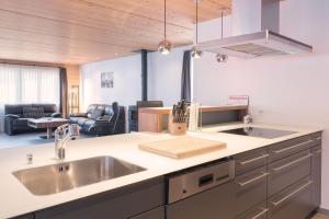 a kitchen with a sink and a living room at Apartment Renata in Grindelwald