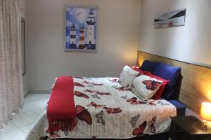 1 dormitorio con 1 cama con edredón en Villa Pesca Self Catering accommodation, en Richards Bay