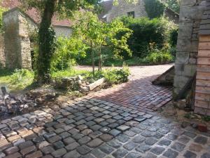 a brick walkway with a tree in a yard at gite d'Albertine in Ully-Saint-Georges