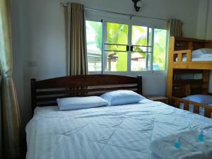 a bedroom with a bed with blue pillows and a window at Open Kitchen in Chiang Rai