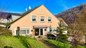 a house with a mountain in the background at Moselina Gästezimmer in Sankt Aldegund