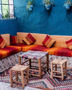un sofá con 2 mesas y 2 taburetes en RIAD BORJ JAMAA LAFNA, en Marrakech