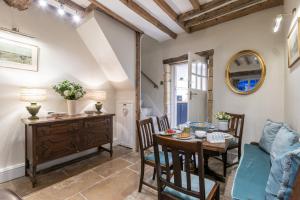 a dining room with a table and chairs and a desk at Bankside Cottage in Blockley