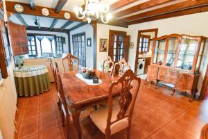 a dining room with a wooden table and chairs at Casa Rural El Mirador del Pico in Santa Cruz del Valle