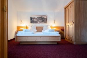 een slaapkamer met een bed met witte lakens en kussens bij DAS Hintersee in Hintersee