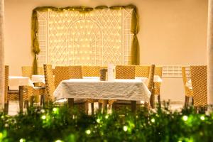 a table and chairs with a white table and a doorway at Arndt Hotel Garni in Rust