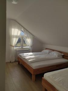 sypialnia z 2 łóżkami i oknem w obiekcie Apartman MiMa w mieście Pale