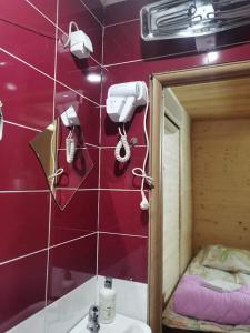 W łazience znajduje się fioletowa ściana z lustrem i kamerą. w obiekcie Kamp Bungalovi Sase drvena kuca w mieście Wiszegrad