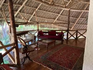 a living room with a red couch and a rug at Gulu House in Malindi