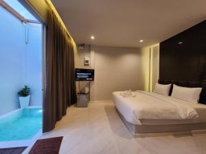 a bedroom with a large bed and a swimming pool at PVILLA in Ban Phraek Sa