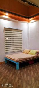 Bett in einem Zimmer mit Fenster in der Unterkunft Apar Beach Resort in Mataba
