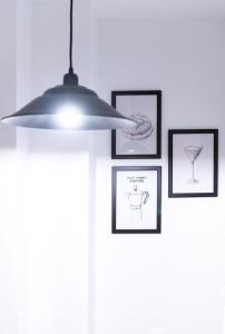 une lampe suspendue dans une pièce avec des photos sur le mur dans l'établissement Nordik Rooms Urban - Centro "Helsinki", à Malaga