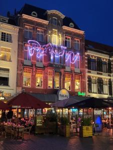 een hotel met verlichting aan de zijkant van een gebouw bij Hotel Pauw in Nijmegen