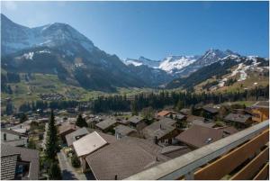 a view of a town with mountains in the background at Appartement au calme avec vue magnifique in Adelboden